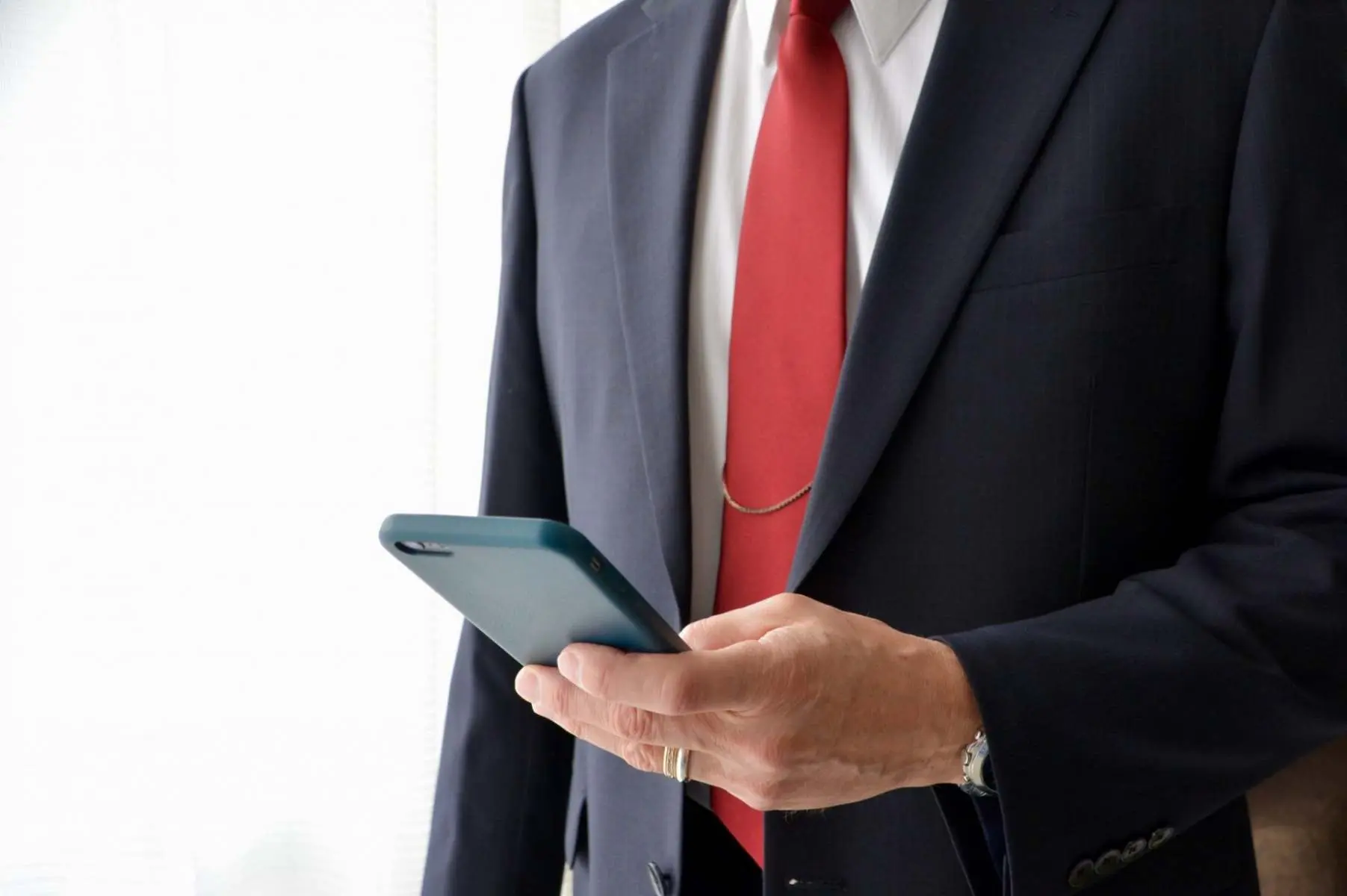 Business professional using a mobile phone Belinos Consulting London
