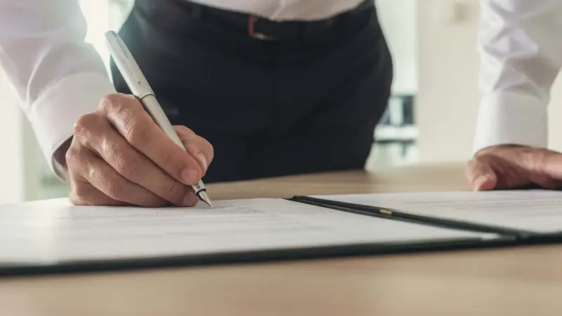 Businessman signing a contract Belinos Consulting financial crime London