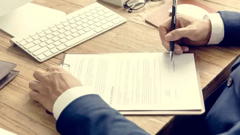 Business man signing terms and conditions Belinos Consulting London